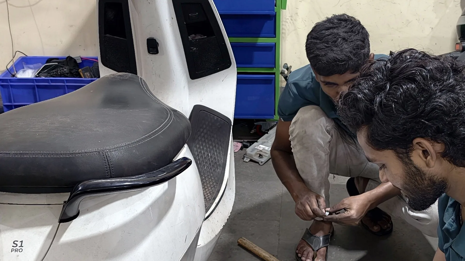 Technicians servicing an Ola electric scooter at the EV Doctor workshop in Bangalore